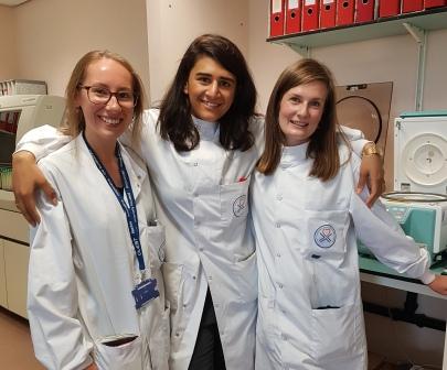 Biomedical staff from Glasgow smile and pose for a photo in lab coats. 