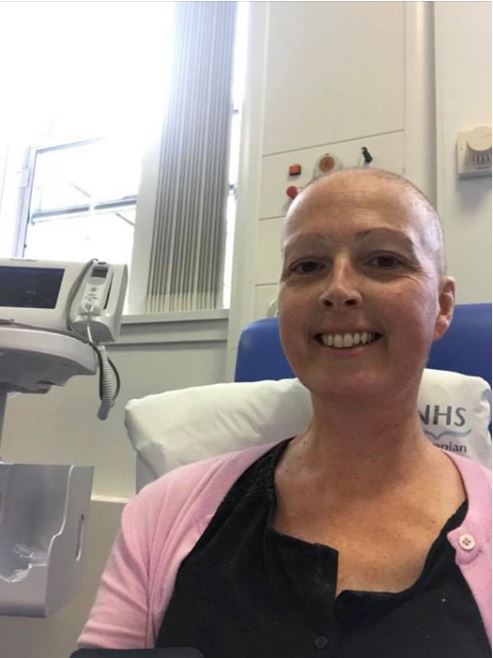 Jemma smiles as she sits receiving her blood transfusion. 