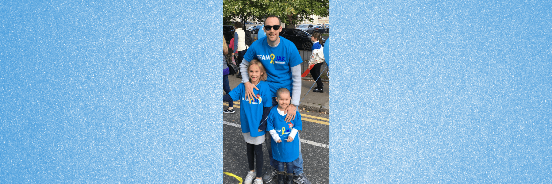 Keith stands smiling with daughters Jessie and Edie. 