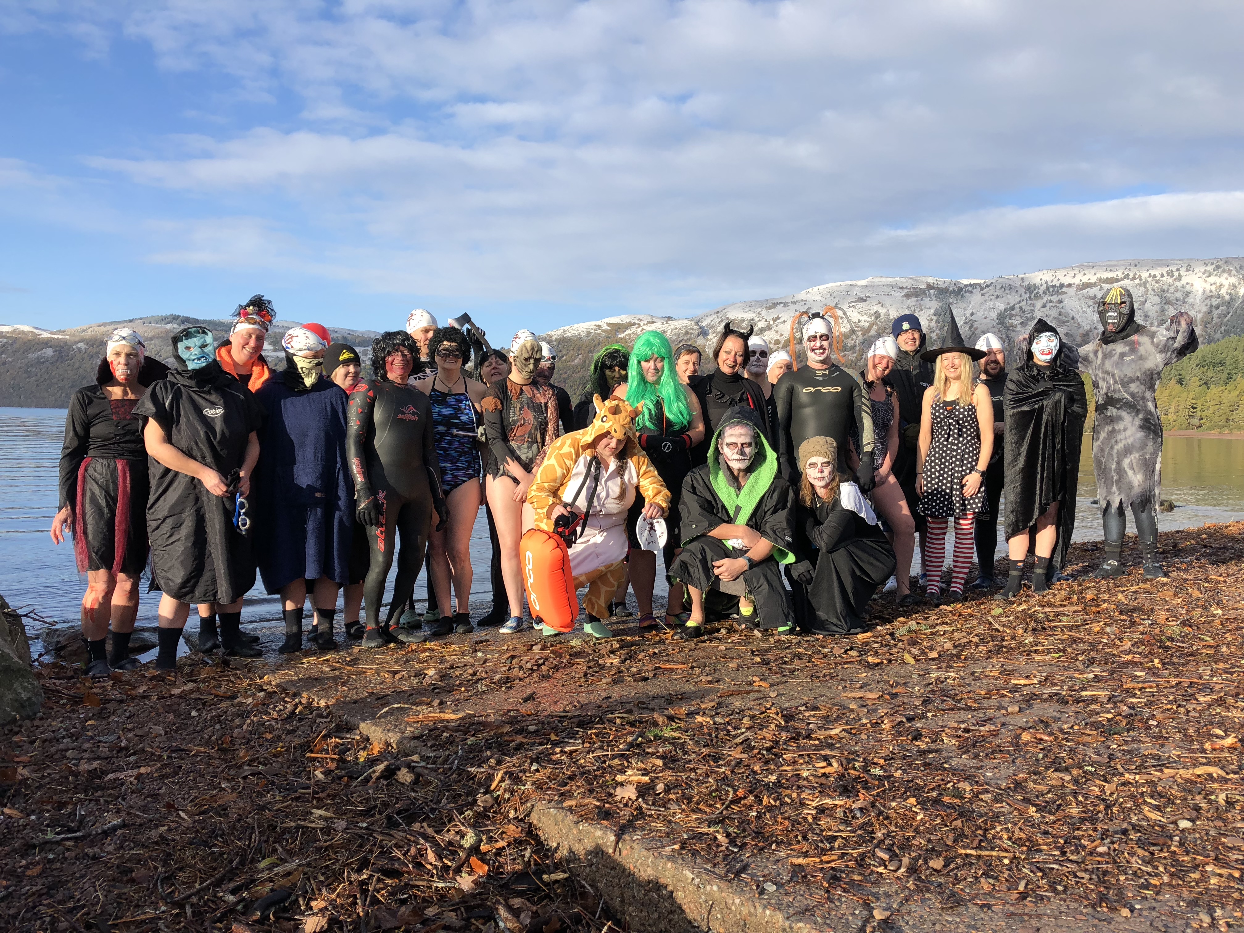 Highlanders stand on the edge of Loch Ness dressed up in Halloween fancy dress costumes.