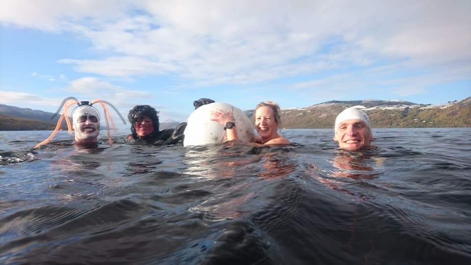 Four swimmers hold on to float while in swimming in Loch Ness. 