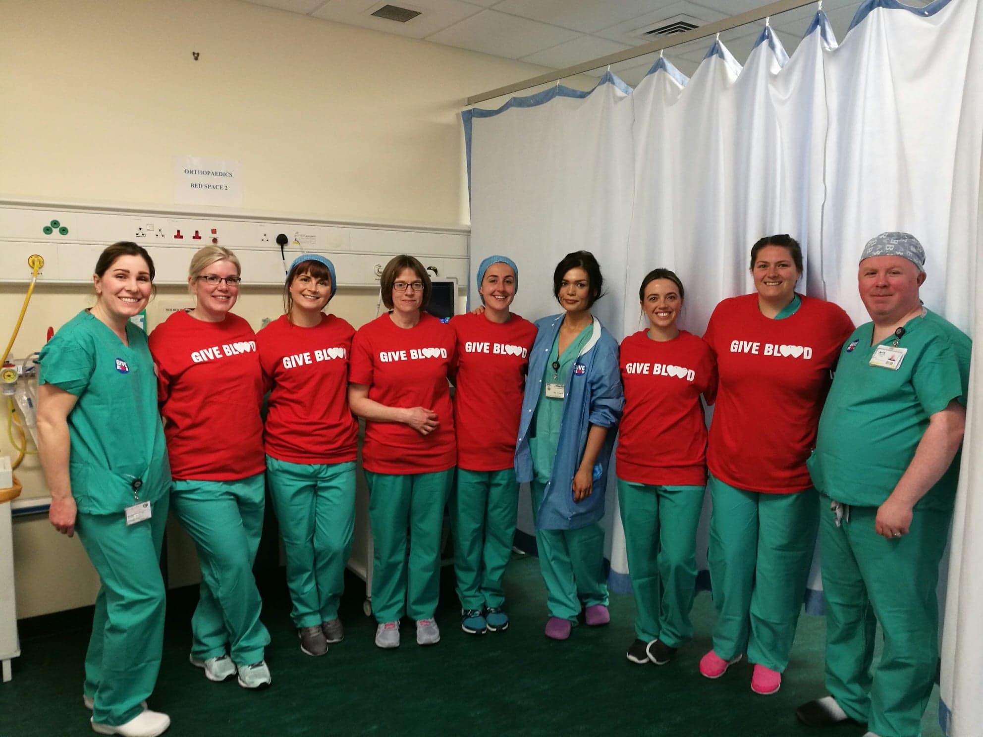 Group photo of the Edinburgh Royal Infirmary team dressed in scrubs and Give Blood t-shirts. 